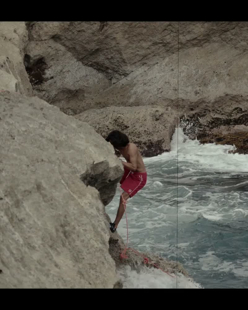 Diego Vázquez Torres en la base de la pared, con la soga en la mano y el mar reventando